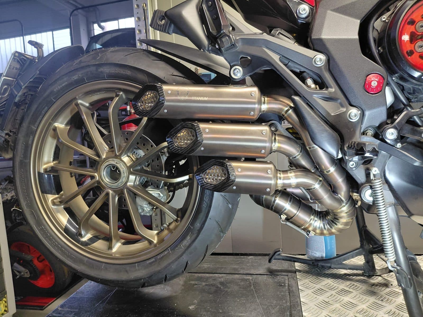 Scarico tre canne bronzo montato su MV Agusta sul cavalletto in officina